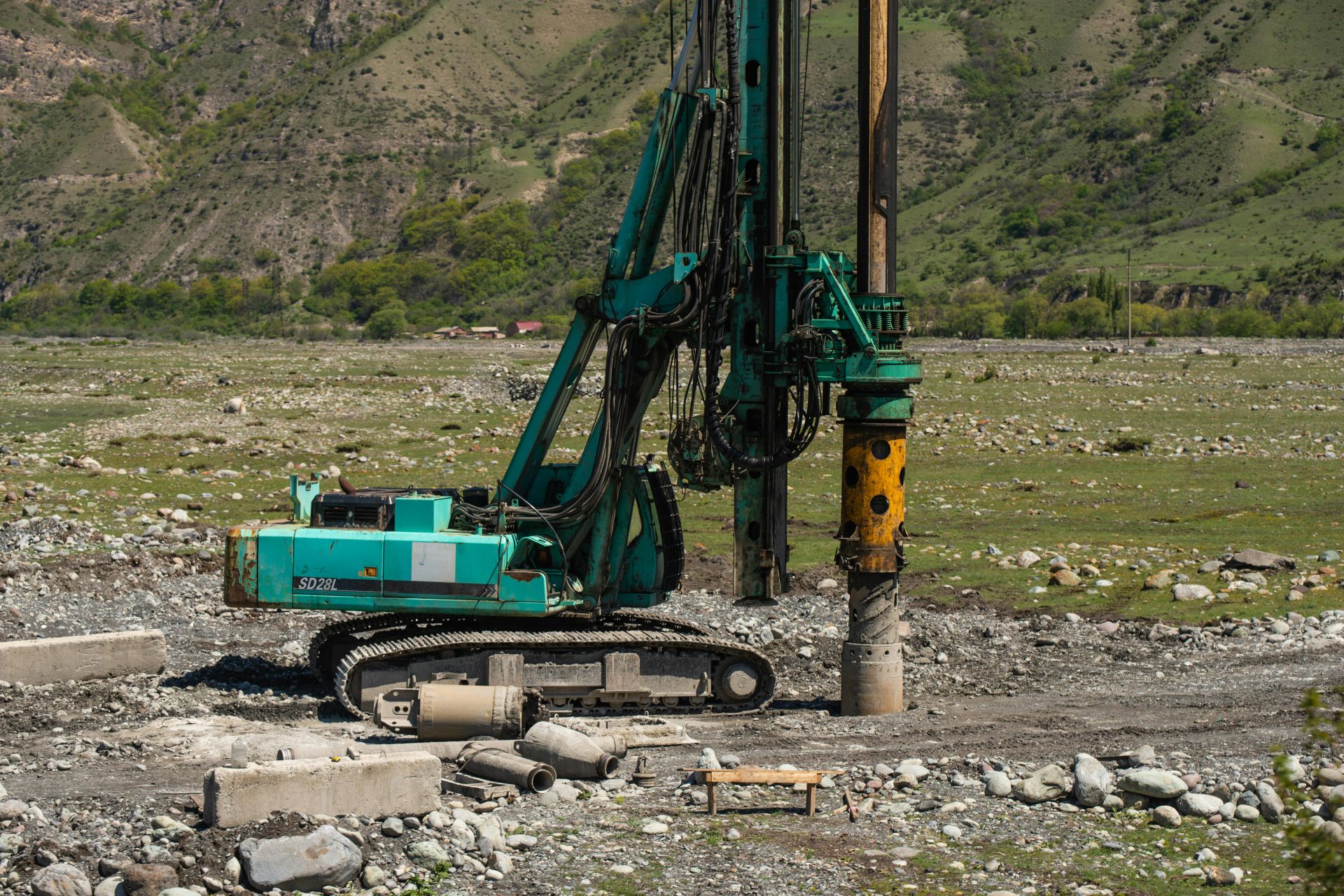 Eine schwere Bohrmaschine im Einsatz auf einer anspruchsvollen Baustelle im Freien.